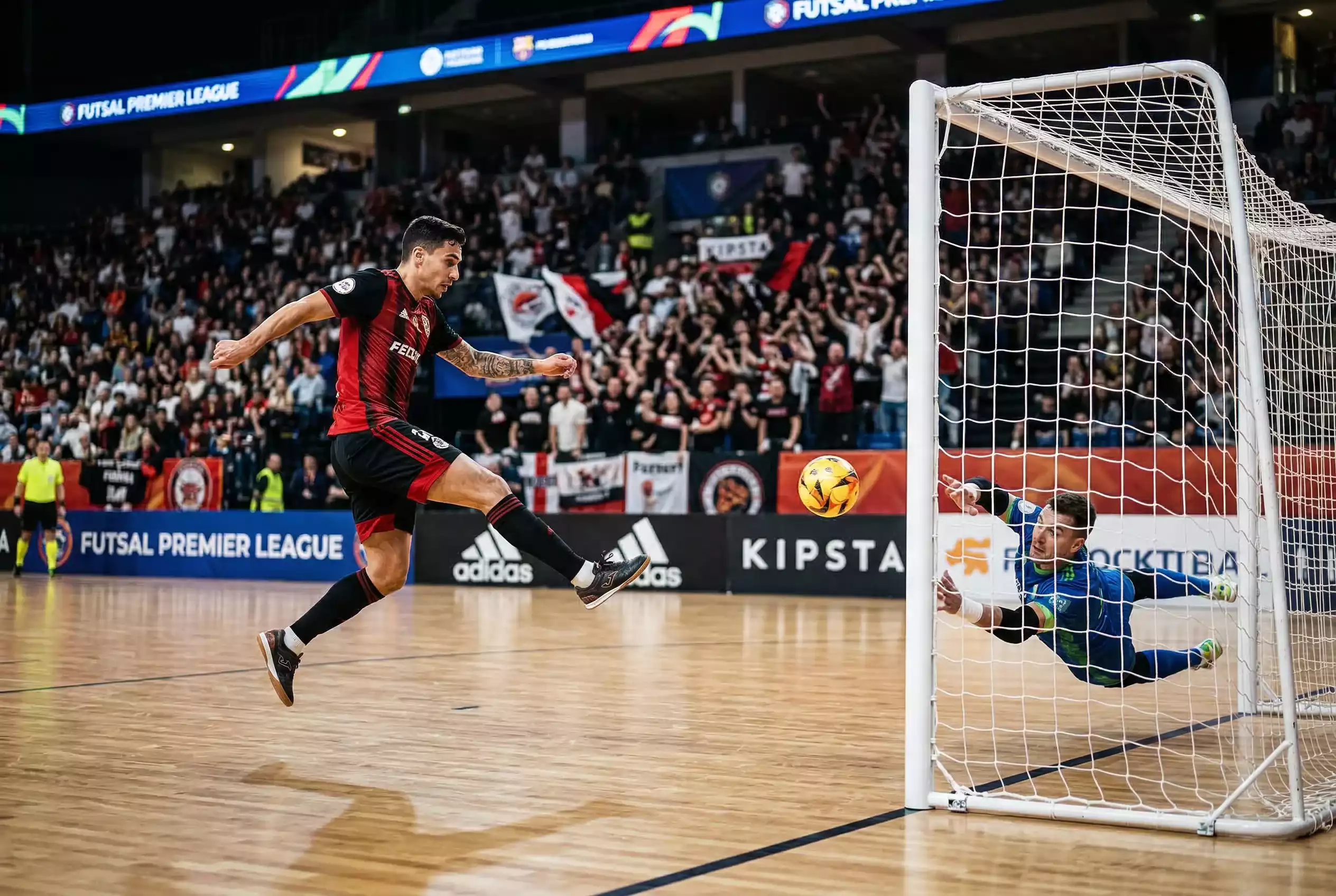 Jogador de futsal a rematar para marcar o primeiro golo do jogo